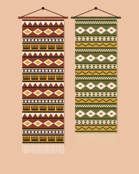 Two woven hangings side by side on a blush wall, one in red, cream and mustard, the other in olive, cream and terracotta.