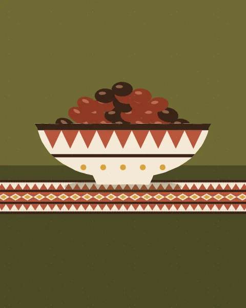 A cream bowl decorated with terracotta triangles and mustard dots, heaped with dates, on a woven cloth.