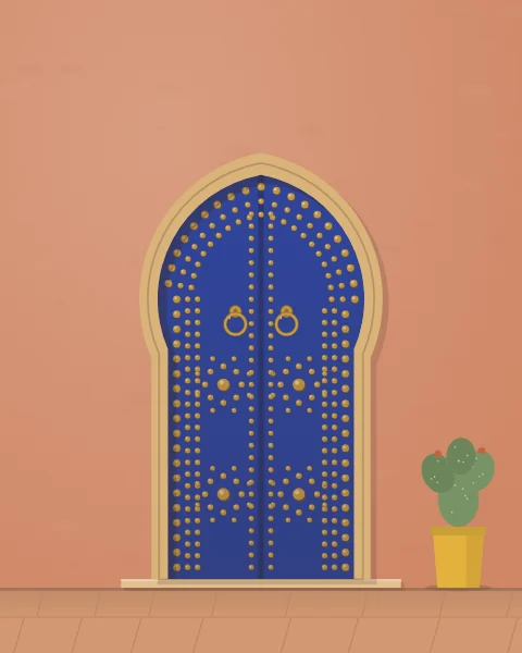 A deep blue door in a pointed horseshoe arch, studded in brass rings and stars, with two brass ring knockers on a terracotta wall.