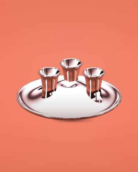 Three chrome tea glasses stand on a round chrome tray, seen from slightly above on a coral ground.