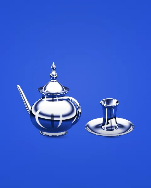 A chrome Moroccan teapot stands beside a tea glass on its saucer, on a cobalt blue ground.