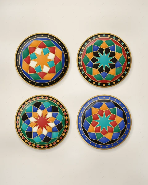 Four enamel plates in cobalt, carnelian, emerald and black, each centred on a gold-lined star rosette with its own rim of dots, beads or kites.