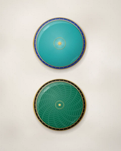 Two quiet enamel plates, one turquoise and one emerald, whose glassy colour lies over fine engine-turned rays and ripples, each with a narrow rim of gold dots.