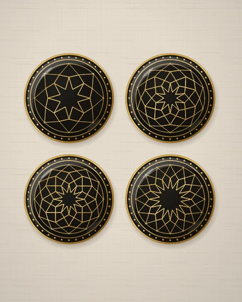 Four black enamel plates drawn only in gold line, each with a different star rosette of eight, ten, twelve or sixteen points closing on a gold ring, on oatmeal linen.