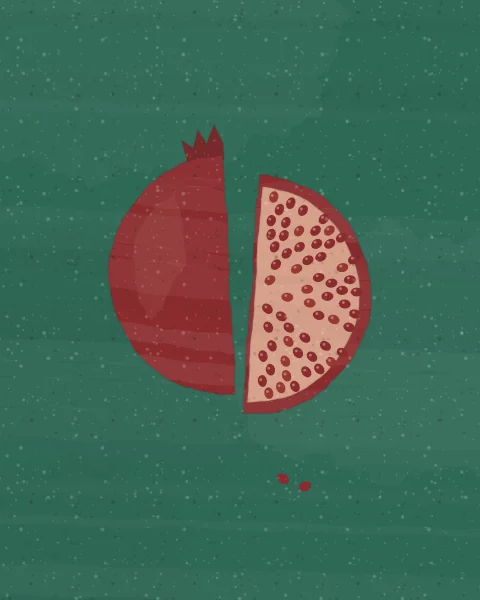 A pomegranate cut in two lies on deep malachite, one half showing its crowned skin, the other its rose pith and red seeds.