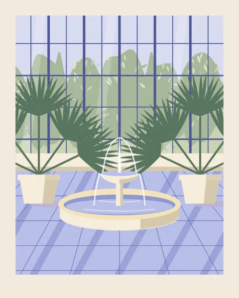 A small stone fountain plays in the middle of a glasshouse floor, between two potted fan palms, with the glazed wall and the garden beyond.