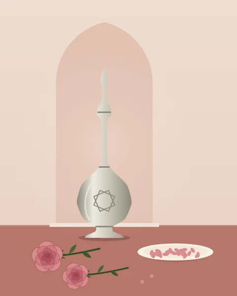 A gulabdan, the tall slender-necked sprinkler used for rosewater, in engraved silver standing in a shallow niche against a blush wall. Two damask roses with their stems and leaves lie on the rose table in front, and a white dish holds a heap of pink petals.