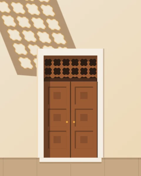 A panelled cedar door with a turned lattice transom in a pale wall, crossed by the patterned shadow of a window above.