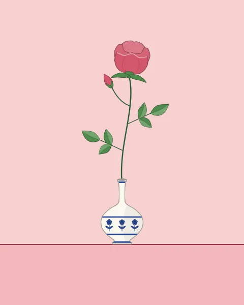One long-stemmed pink rose with a bud and leaves in a small white flask painted with blue flowers, standing on a ledge against pale rose.