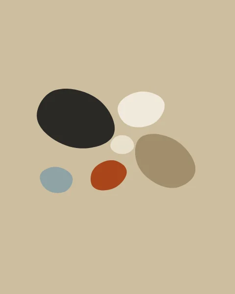 Seen from above, six smooth pebbles of different sizes lie loosely grouped on sand: charcoal, cream, pale paper, slate, clay and a darker sand.