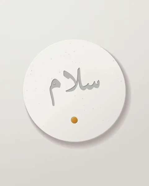 A single plaster disc with salam incised in Naskh script and one small ochre tile set beneath it.
