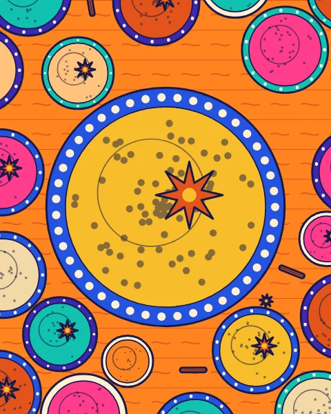 Bowls of ground spice seen from above on a wooden table, with star anise and cinnamon between them.