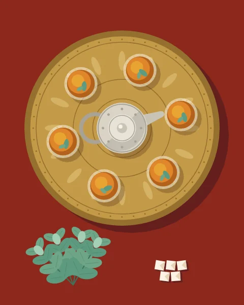 A round brass tray seen from above, set with a teapot and glasses of mint tea, with fresh mint and sugar cubes beside it.