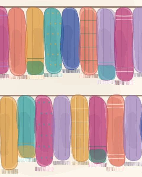 A market stall hung with rows of scarves, striped, dotted, checked and plain, overlapping in bright colour.