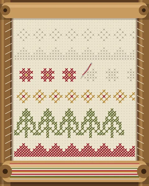 A long border piece laced into a wooden scroll frame. Finished bands are wound onto the bottom roller as stripes, bands in madder, gold and olive are worked up the cloth, one stops mid-row with its needle parked, and pencilled bands wait above.