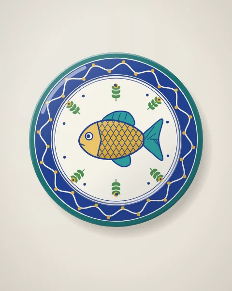 A round plate hung on a white wall, painted with a yellow fish, green sprigs and a cobalt border of waves and dots.