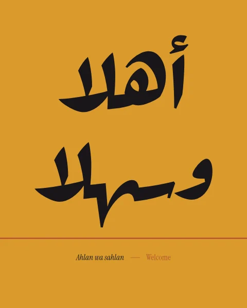 The greeting ahlan wa sahlan, welcome, in a bold display face in ink on saffron, standing on a thin terracotta line like a threshold.
